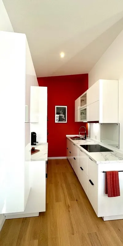 Cuisine posée avec mur rouge et façades blanches